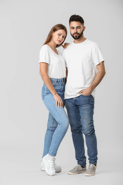 Jeune couple élégant en jeans sur fond blanc
 - Photo, image