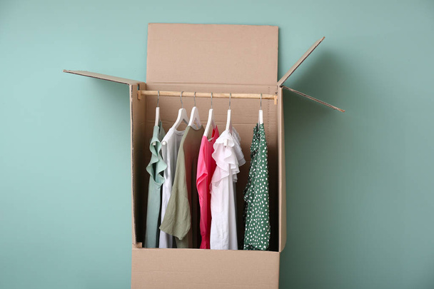 Garderobenbox mit Kleidung auf farbigem Hintergrund - Foto, Bild