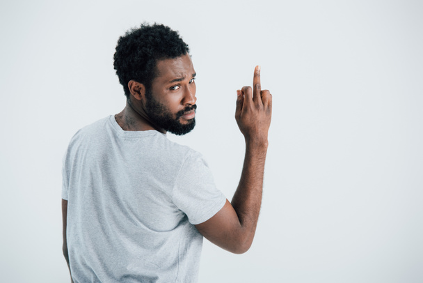 Afrikanisch-amerikanischer Mann in grauem T-Shirt zeigt Mittelfinger isoliert auf grau - Foto, Bild