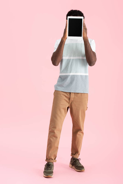 African American Man pokazano cyfrowy tablet z pustym ekranem na białym tle na różowy - Zdjęcie, obraz