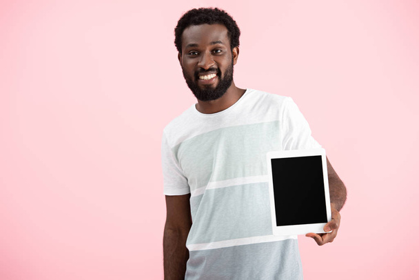 uśmiechnięty African American Man pokazano cyfrowy tablet z pustym ekranem na białym tle na różowy - Zdjęcie, obraz