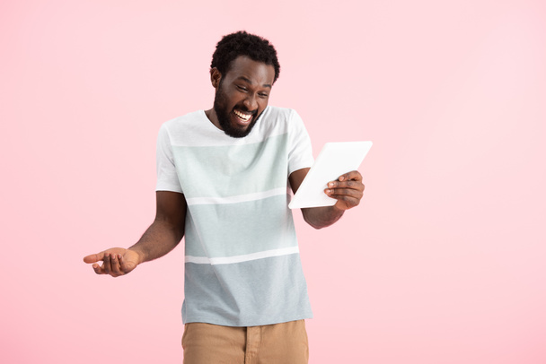 homem americano africano alegre ter vídeo chat em tablet digital isolado em rosa
 - Foto, Imagem