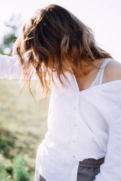 Portrait de femme en chemise salissante avec soutien-gorge en dentelle posant à l'extérieur
 - Photo, image