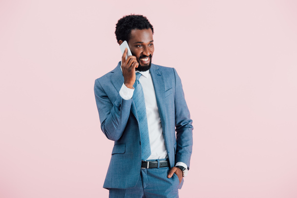 apuesto hombre de negocios afroamericano hablando en smartphone, aislado en rosa
   - Foto, Imagen