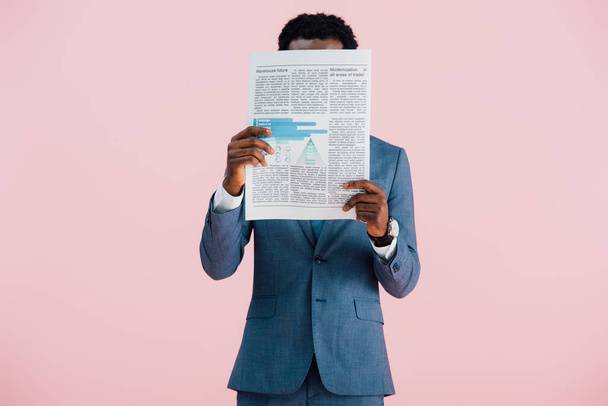 african american businessman reading newspaper isolated on pink - Fotoğraf, Görsel