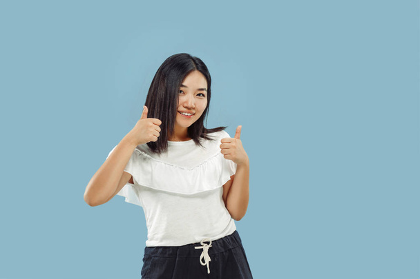 Korean young woman's half-length portrait on blue background - Foto, afbeelding