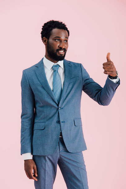 young african american businessman in suit showing thumb up, isolated on pink - Foto, Imagen