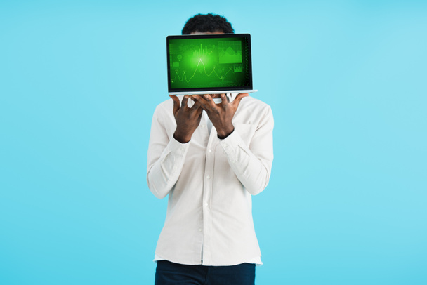 Afrikanisch-amerikanischer Mann zeigt Laptop mit Grafik isoliert auf blau - Foto, Bild