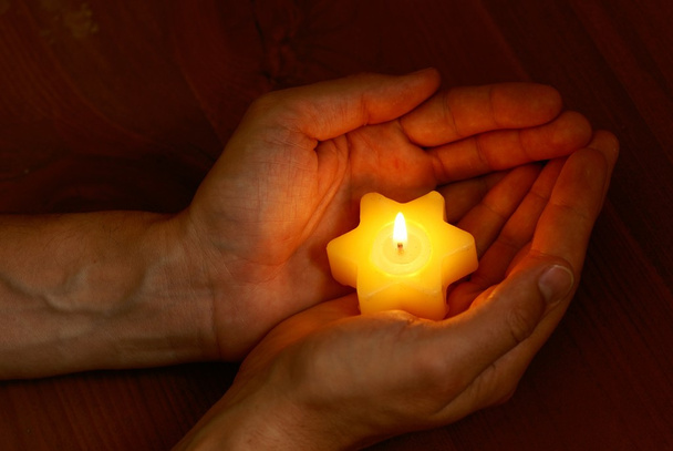 Dettaglio delle mani con candela accesa
 - Foto, immagini