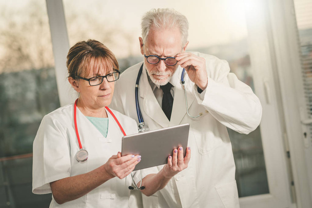 Two doctors discussing about medical report on tablet - Photo, Image