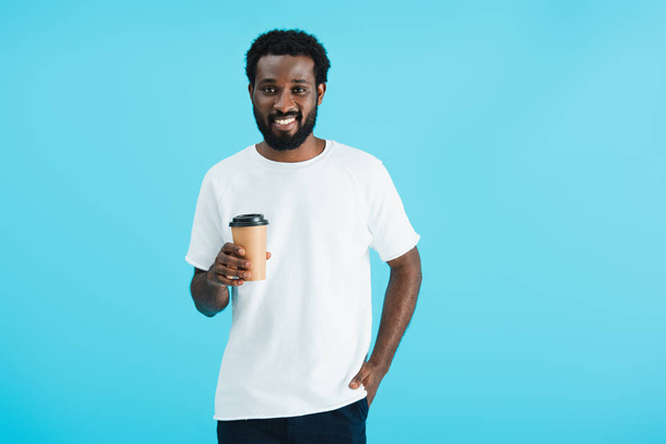 cheerful african american man holding coffee to go, isolated on blue - Foto, immagini