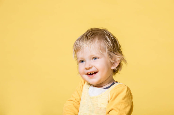 Young Baby Girl in Yellow Dress on Yellow Background - Фото, изображение