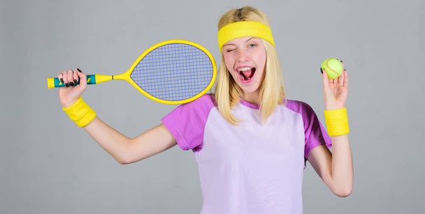 Sport for maintaining health. Active leisure and hobby. Athlete hold tennis racket in hand on grey background. Tennis sport and entertainment. Tennis club concept. Girl adorable blonde play tennis - Photo, Image
