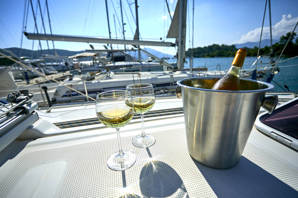 ヨットにボトル付きの白ワインとバケツ付きワイングラスのペア - 写真・画像