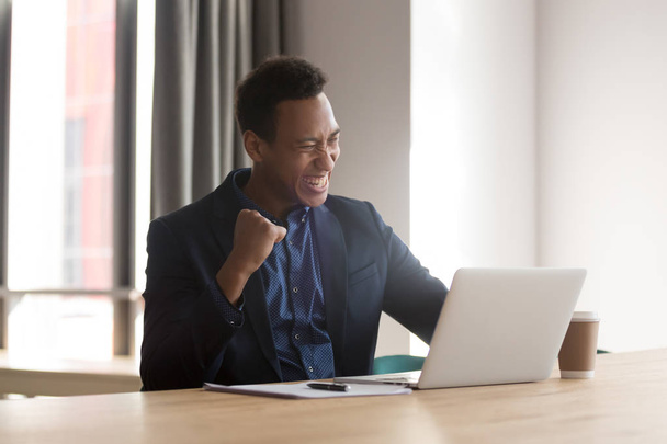 Excited black businessman feel euphoric reading good news online - Valokuva, kuva