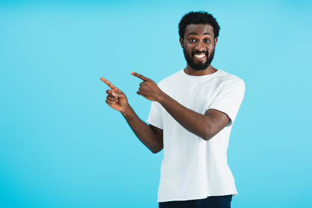 joyeux homme afro-américain pointant isolé sur bleu
 - Photo, image