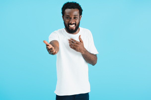 happy young african american man laughing and gesturing isolated on blue - Foto, immagini