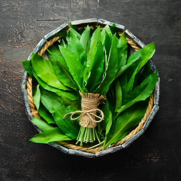 Fresh wild garlic leaves in a wooden box. Wild leek. Top view. Free space for your text. - Foto, Imagem