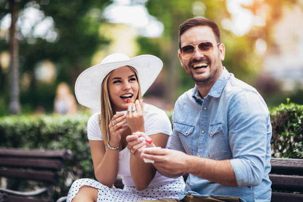 Couple joking and having fun while eating an ice cream in the pa - Photo, Image