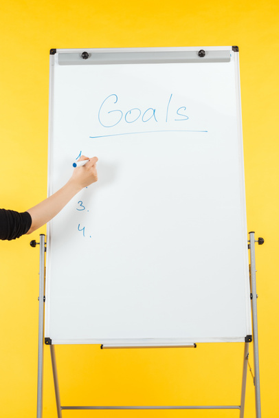 cropped view of businesswoman writing goals list on white flipchart with copy space - Valokuva, kuva