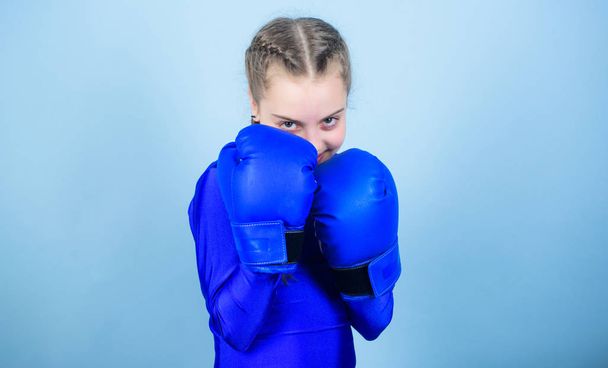 Girl cute boxer on blue background. With great power comes great responsibility. Boxer child in boxing gloves. Rise of women boxers. Female boxer change attitudes within sport. Free and confident - Photo, Image