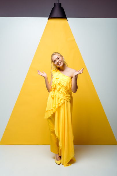 pretty young woman gesturing and posing on white and yellow  - Foto, Imagen