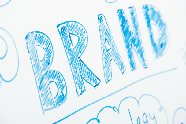 close up view of word brand written on white flipchart - Foto, afbeelding