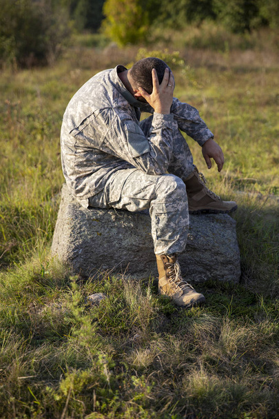 Il soldato si siede e riposa. Soldato triste. Soldato stanco
. - Foto, immagini