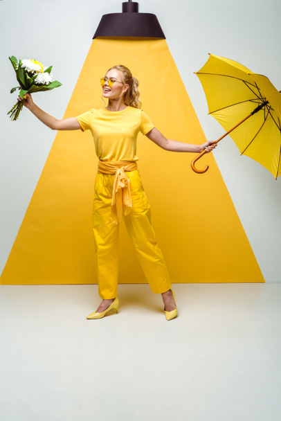 gaie fille blonde regardant des fleurs tout en tenant parapluie sur blanc et jaune
  - Photo, image
