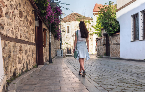 Young girl tourist walking through the deserted streets of the old town of Kaleici in Antalya - 写真・画像