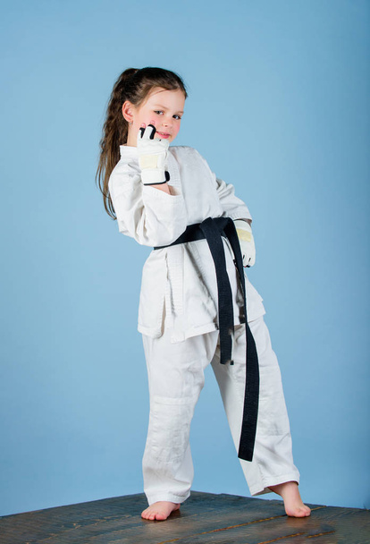little girl in gi sportswear. practicing Kung Fu. happy childhood. sport success in single combat. small girl in martial arts uniform. knockout. energy and activity for kids. Energy inside - Photo, Image
