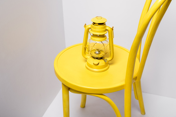 lámpara vintage en silla amarilla y cómoda en blanco
  - Foto, Imagen