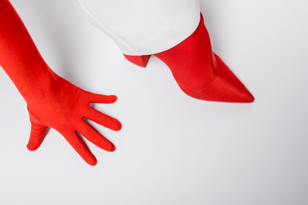cropped view of stylish woman in red glove and shoe on white  - Fotografie, Obrázek