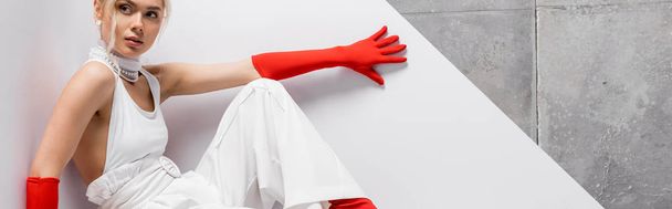 panoramic shot of attractive and stylish woman in red gloves on white and grey  - Fotó, kép