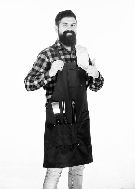 Giving thumbs up to his barbeque. Grill cook happy smiling at barbeque party. Bearded man wearing barbeque apron with grilling tools in pockets. Cooking and serving barbecue foods - Φωτογραφία, εικόνα