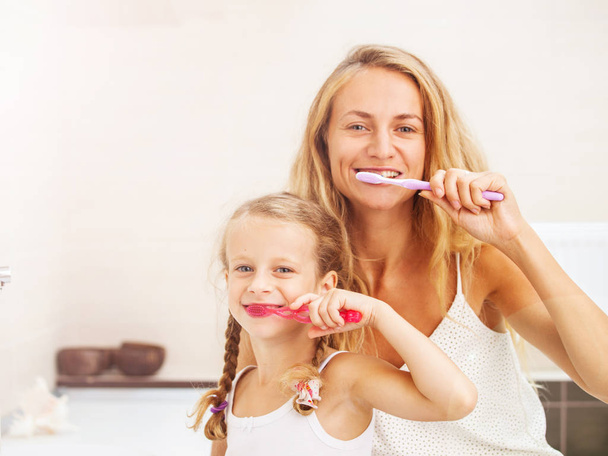 Mother and daughter brushing their teeth - Foto, afbeelding