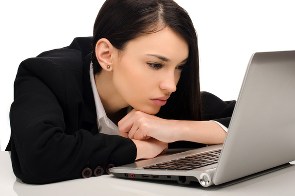 Beautiful brunette businesswoman working on a laptop at her office - Фото, зображення