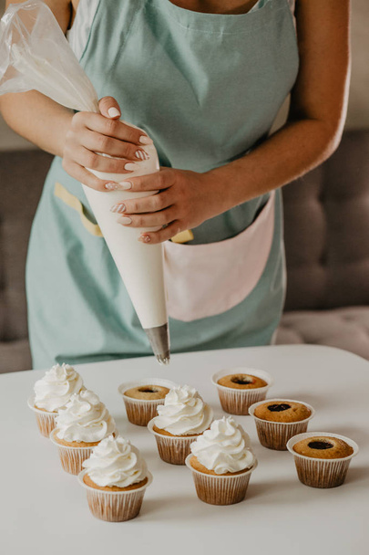 woman in apron cooking dessert - Foto, afbeelding