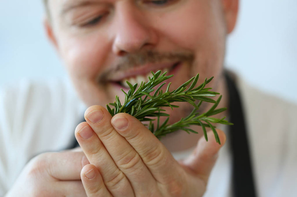 Uśmiechnięty szef kuchni Holding Green Rosemary herb pęczek - Zdjęcie, obraz