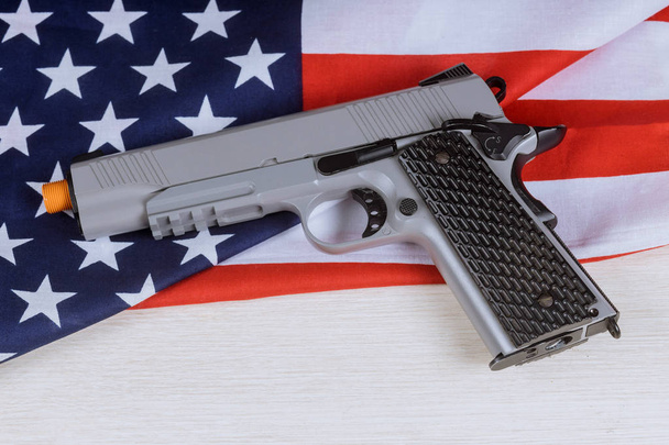 Πιστόλι όπλου στην αμερικάνικη σημαία, έγκλημα και τιμωρία. - Φωτογραφία, εικόνα