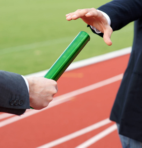 Businessman passing green baton in relay race - Photo, Image