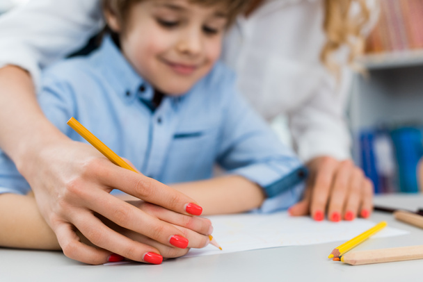 selective focus of woman drawing with happy kid  - Photo, Image