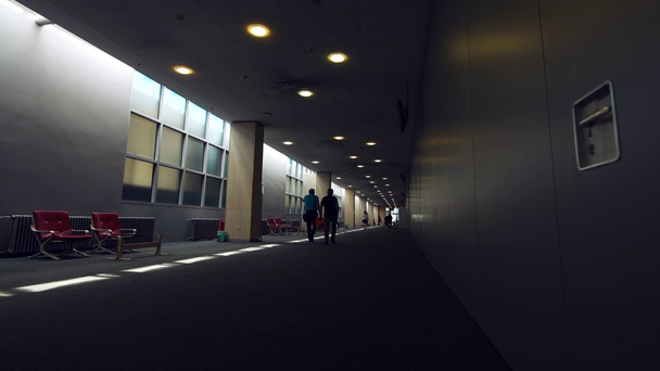 Felismerhetetlen üzletemberek séta a sötét folyosón a nagy cég épület - Felvétel, videó