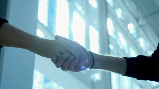 A disabled person without a hand with a prosthesis shakes hands with a business partner. Handshake prosthesis on the background of a large window in the business center. Full life with a prosthesis. - Footage, Video