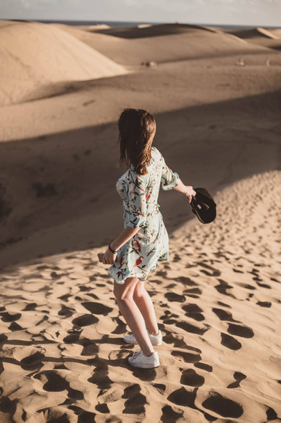 woman in the desert on her back with a mobile phone in her hand - Foto, Bild
