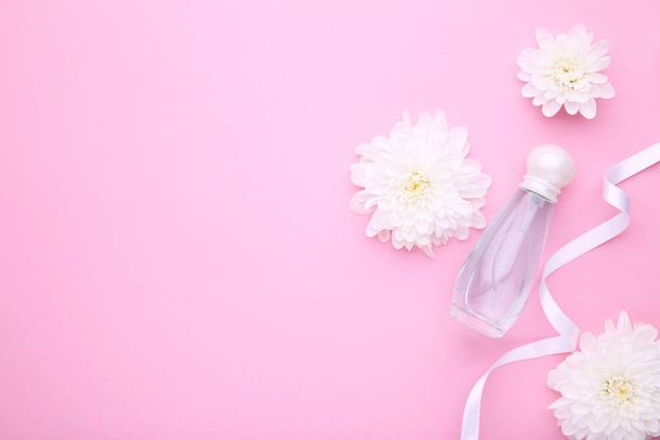 Perfume bottle with flowers on pink background - Zdjęcie, obraz