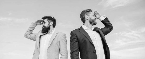 Changing course. Men formal suit managers looking at opposite directions. New business directions. Developing business direction. Businessmen bearded faces stand back to back sky background - Photo, image