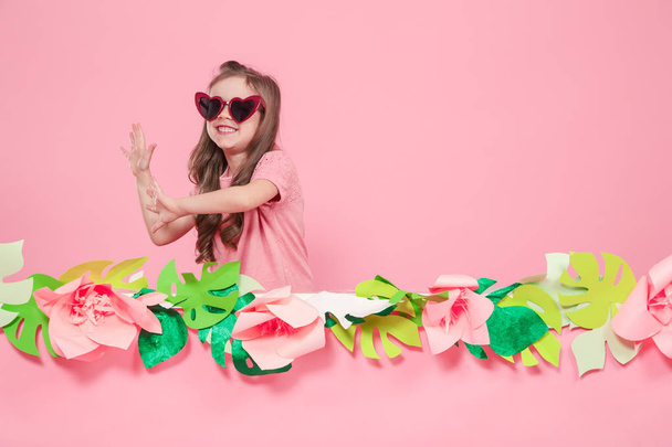 Portrait of a little girl with sunglasses on a pink background - Foto, imagen