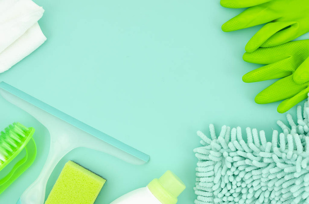 Top view mockup green cleaning supplies isolated on blue background. Flat lay frame with copy space - Valokuva, kuva
