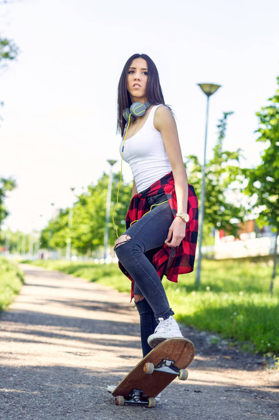 Beautiful girl skateboarder skateboarding in park - Fotografie, Obrázek
